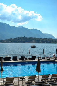 Scenic view of swimming pool by lake against sky