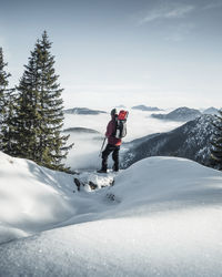 Germany, bavaria, ammergau alps, teufelstattkopf, tourist hiking in mountains on winter day