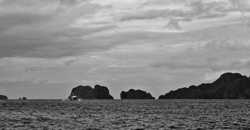 Rocks by sea against sky