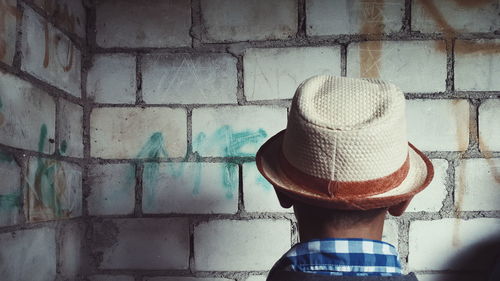 Rear view of man standing against wall