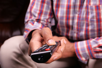 Midsection of man using mobile phone