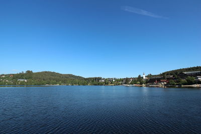 Scenic view of lake against clear blue sky