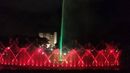 Illuminated city against sky at night