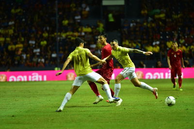 Group of people playing soccer on field