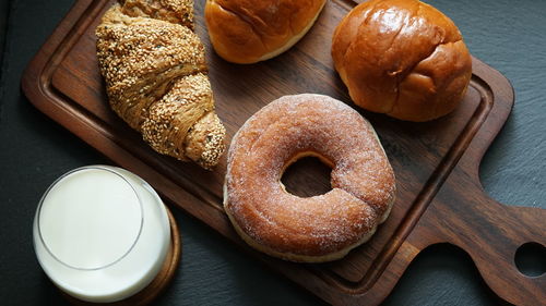 Top view of various pastries on wooden board and a glass of milk