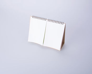 High angle view of blank desk calendar over white background