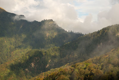 Scenic view of mountains against cloudy sky