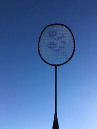 Low angle view of racket against clear blue sky
