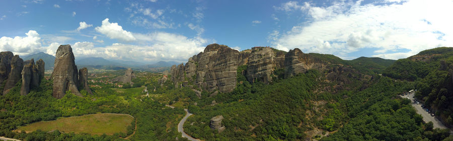 Panoramic view of green landscape and mountains against sky