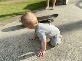 High angle view of boy sitting on road