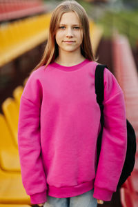 Portrait of a teenage student looking into the camera, against the background of the school stadium