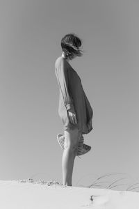 Side view of woman standing on snow