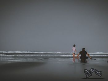 People on beach against sky