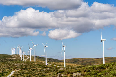 Windmills on field against sky