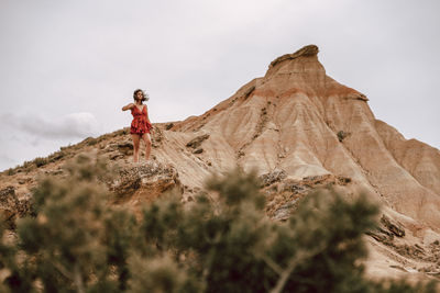 Low angle view of woman standing on rock