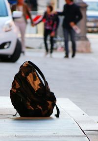 Low section of woman with umbrella on road