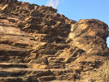 Low angle view of cliff against clear sky