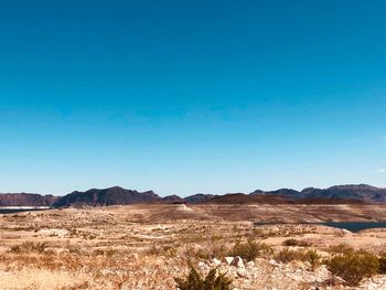 Scenic view of desert against clear blue sky