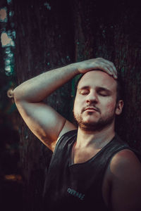 Portrait of young man looking away in forest