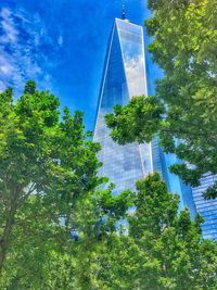 Low angle view of trees and building against sky