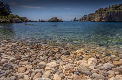 Rocks in sea against sky