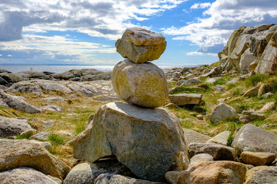 Stack of stones on beach against sky