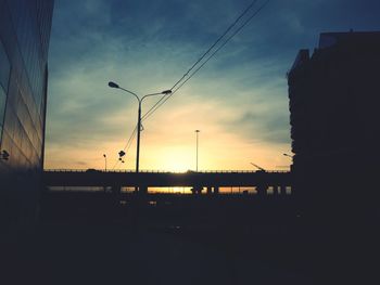 Silhouette street against sky at sunset