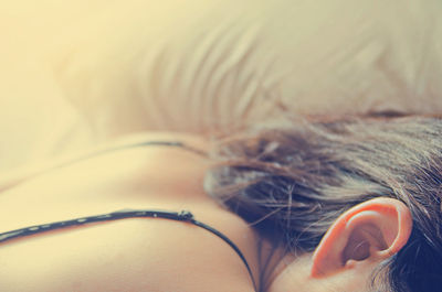 Cropped image of woman sleeping on bed