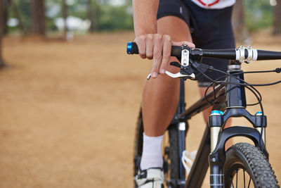 Low section of man riding bicycle on field