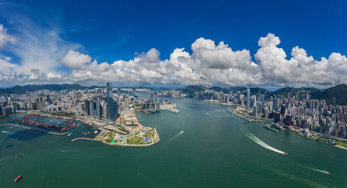 Aerial view of city by sea against sky