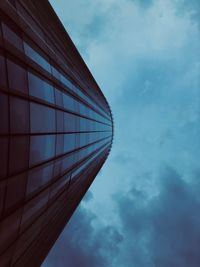 Low angle view of modern building against cloudy sky