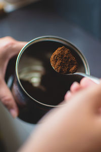 Cropped hand making coffee at table