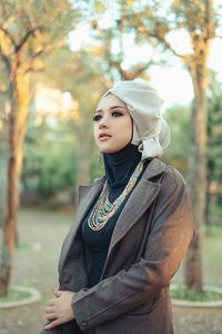 Thoughtful female model standing at park