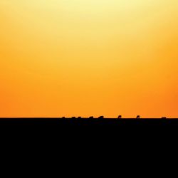 Silhouette landscape against clear sky during sunset