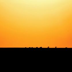 Silhouette landscape against clear sky during sunset