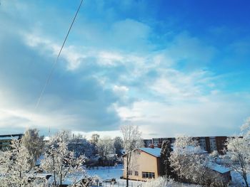 Houses and buildings against sky during winter