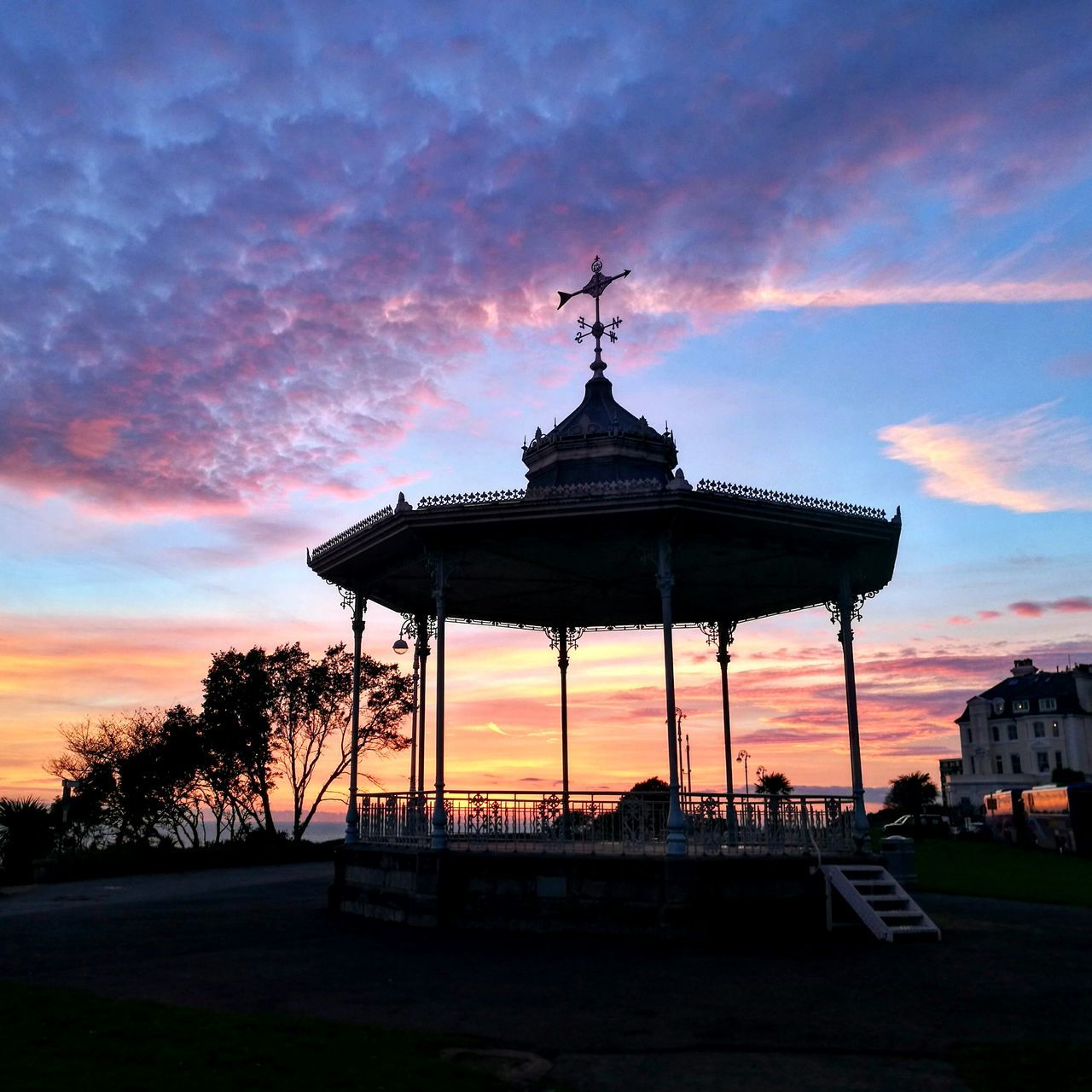 SILHOUETTE OF BUILDING AGAINST CLOUDY SKY DURING SUNSET