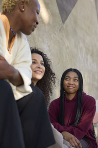 Mother talking together with smiling teenage daughters