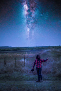 Full length of man standing on field against sky at night