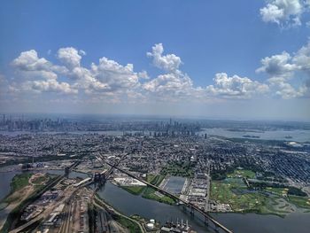 High angle view of city by river against sky