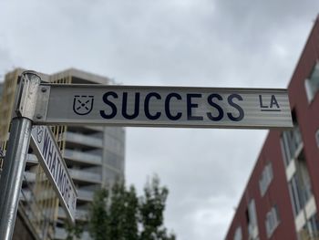 Low angle view of road sign against sky