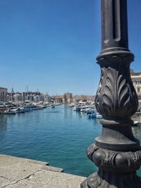 Scenic view of river by city against clear blue sky