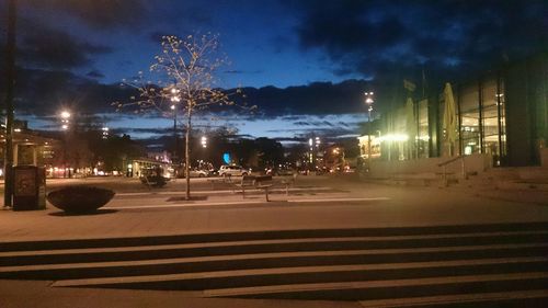 Illuminated street light against sky at night