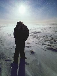 Rear view of silhouette man standing on beach