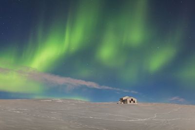 Scenic view of snowy landscape against sky at night during winter