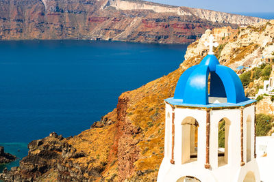 Blue mosque by sea and buildings against mountain