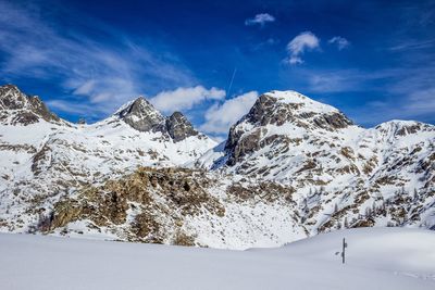 Scenic view of snowcapped mountains against blue sky