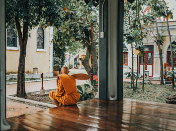 Rear view of senior man sitting outside building