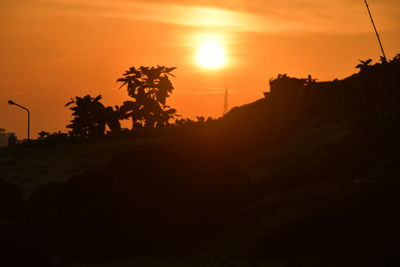 Silhouette palm trees against sky during sunset