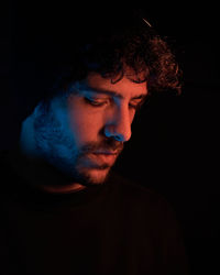 Close-up of young man against black background